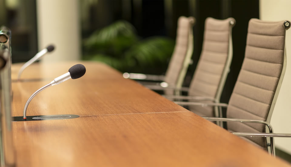 three office chairs and mic on a conference room