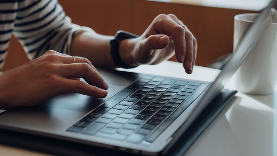 hands touching the mousepad of a laptop